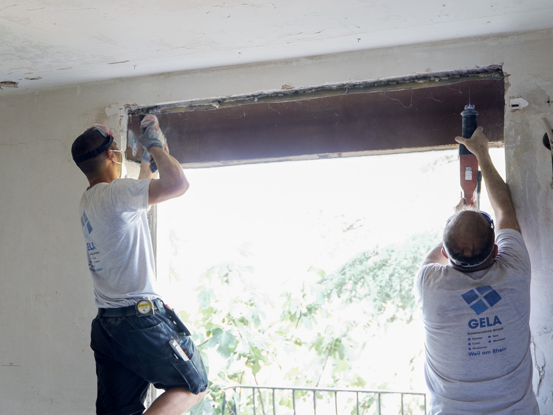Zwei Monteure arbeiten an der Anschlussfuge eines neuen Fensters