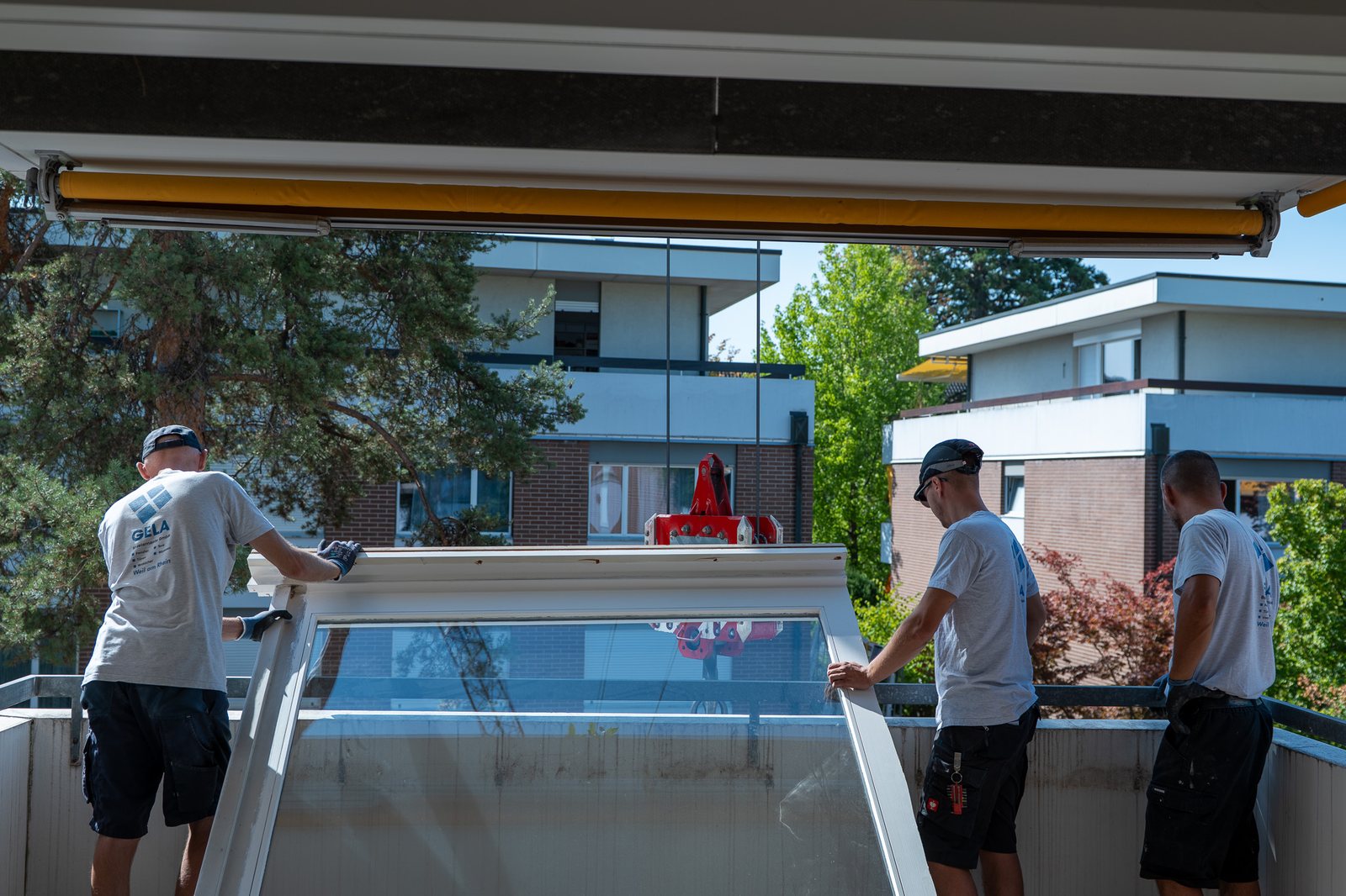 Monteure setzen die neue Scheibe auf dem Balkon ein